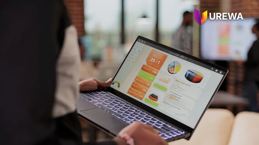 A business user reviewing a live ERP analytics dashboard on a laptop, showing operational and sales performance metrics alongside inventory and supply chain figures