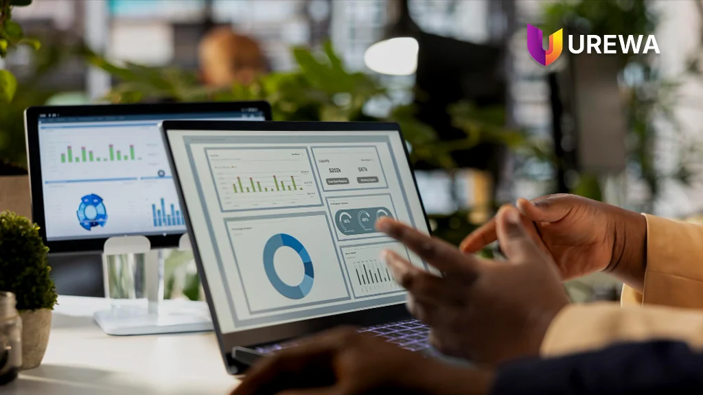 Two colleagues reviewing Dynamics 365 dashboards together on a laptop during user acceptance testing, working through figures and charts on screen to confirm the system supports their real business processes