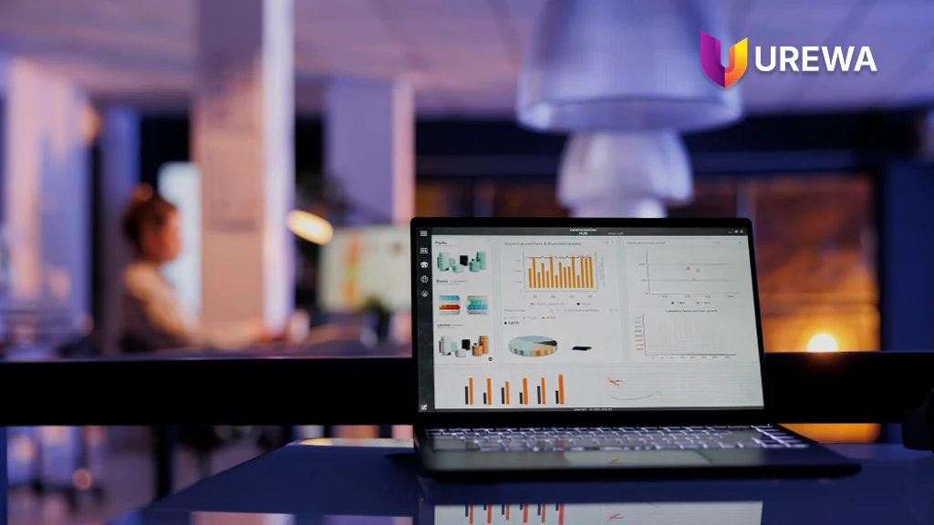 A laptop in a quiet office displaying financial control projections, targets and profitability charts — the kind of enterprise reporting that drives an ERP platform decision